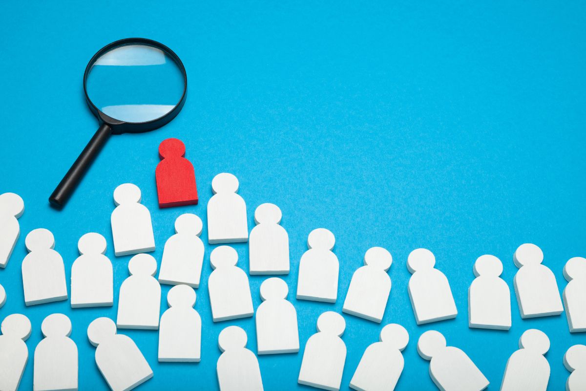 image of a magnifying glass and several people icons representing job search Recruitment services