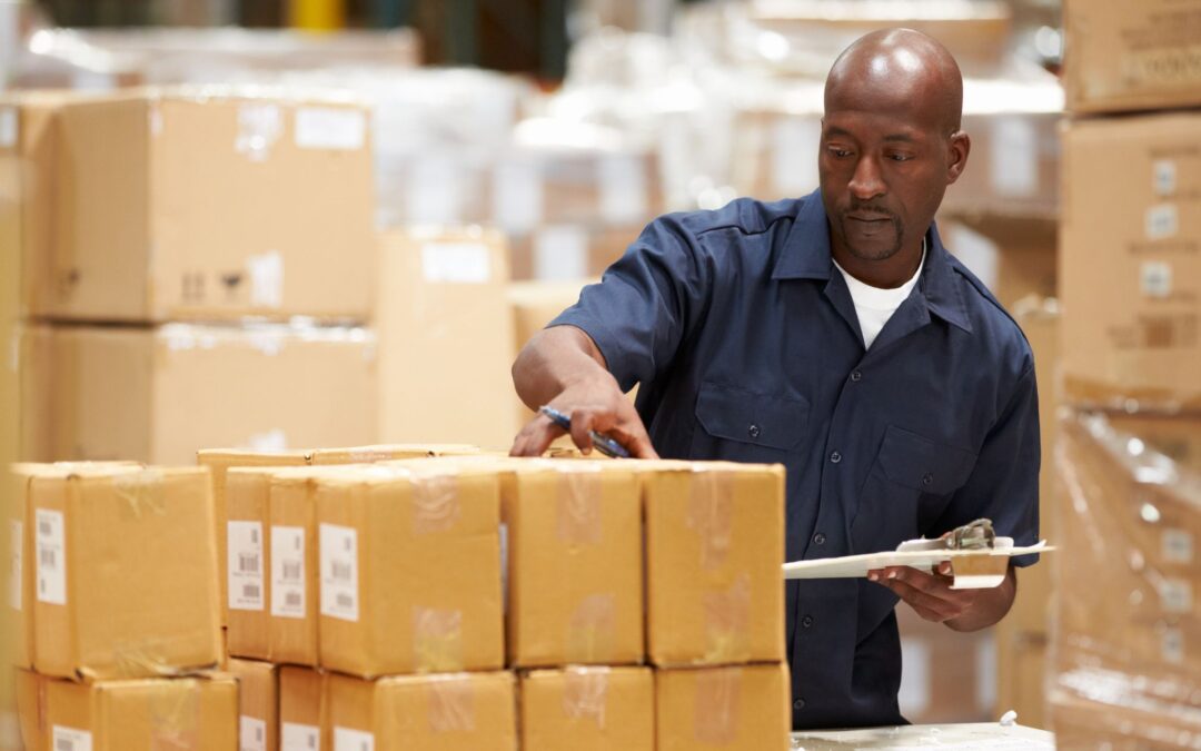 Image of a man checking boxes in a warehouse